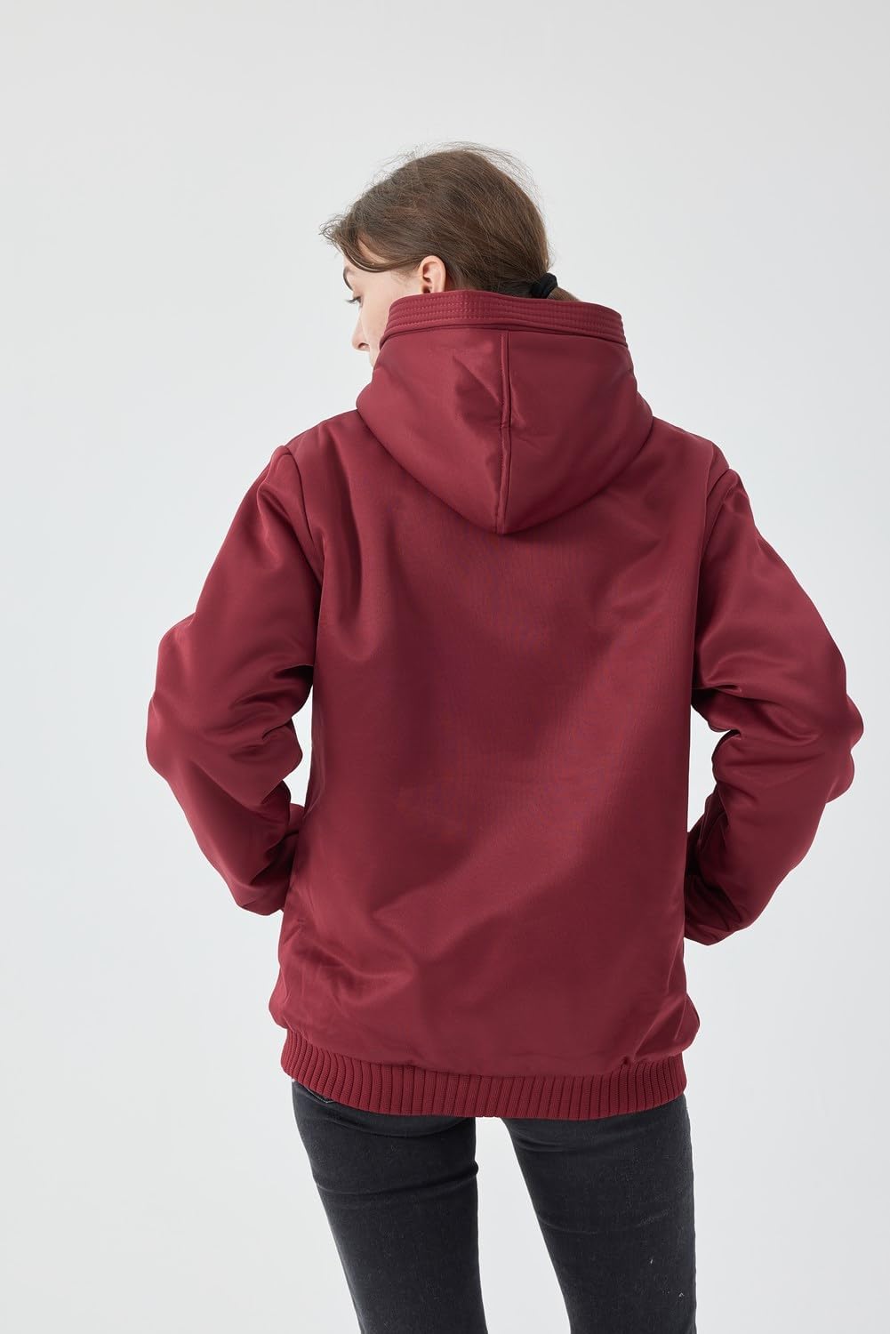 Frau in roter Kapuzenjacke aus Baumwolle, Rückansicht, lässige Wintermode, warm und bequem.