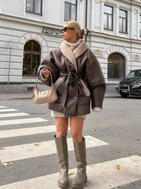 Frau in brauner Oversize-Jacke, beiger Stiefel, Handtasche, Stadtstraße, Herbstmode.