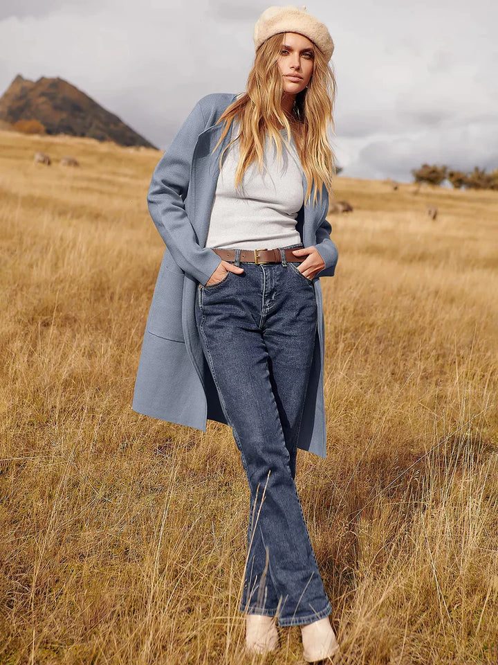Frau in blauer Jacke und Jeans im Herbstfeld, modische Herbstkleidung, Naturhintergrund.