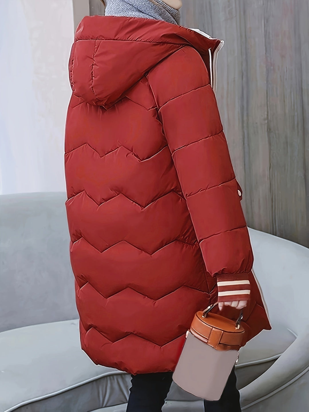 Roter Daunenmantel mit Kapuze, Damenmode, Winterjacke, warm, stilvoll, seitliche Ansicht.