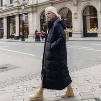 Frau in schwarzem Daunenmantel, beige Stiefel, Stadtstraße, Wintermode, stilvoll, urban.