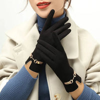 Frau mit schwarzen Winterhandschuhen, goldene Details, eleganter Mantel, modisches Accessoire.