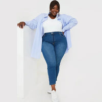 Frau in blauer Jeans und weißem Top, lässige Mode, Plus-Size, lächelnd, Freizeitkleidung.
