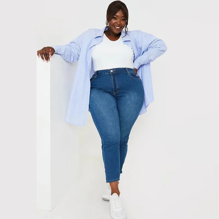Frau in blauer Jeans und weißem Top, lässige Mode, Plus-Size, lächelnd, Freizeitkleidung.