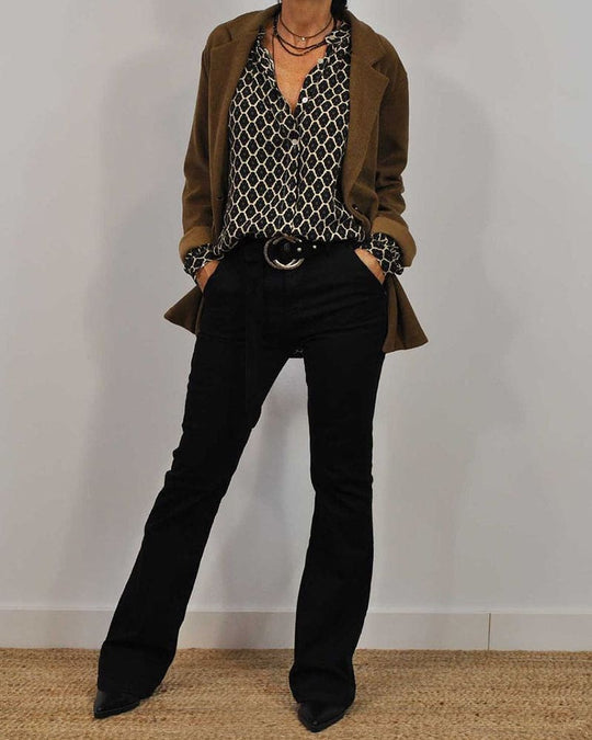 Frau in braunem Blazer, gemusterter Bluse und schwarzer Hose, modisches Outfit, Herbstmode.