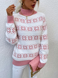 Frau in weiß-rosa Norwegerpullover, goldene Kette, rosa gesteppte Tasche, weiße Hose.