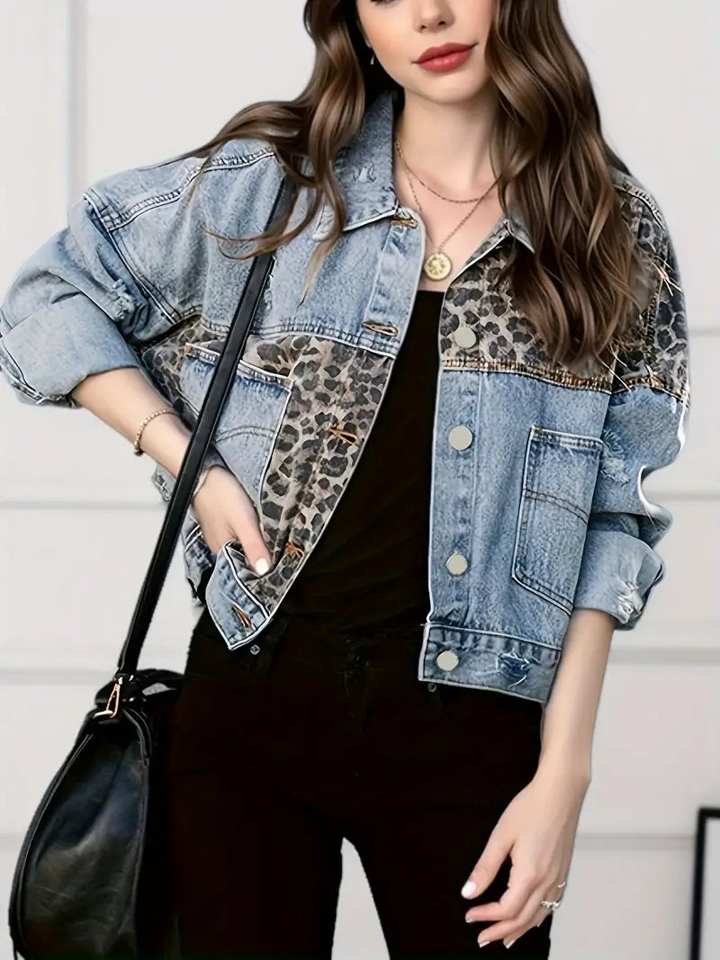 Frau in blauer Jeansjacke mit Leopardenmuster, schwarze Hose, schwarze Tasche, modisch.