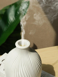 Keramik-Diffusor in Weiß mit Rauch, modernes Design, Aromatherapie, auf Holztisch.