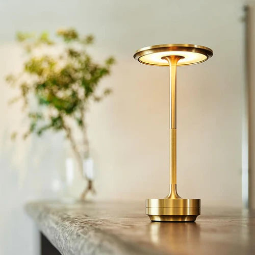 Goldene Tischlampe aus Metall auf Holztisch, modernes Design, LED-Beleuchtung, Wohnzimmer-Dekor.