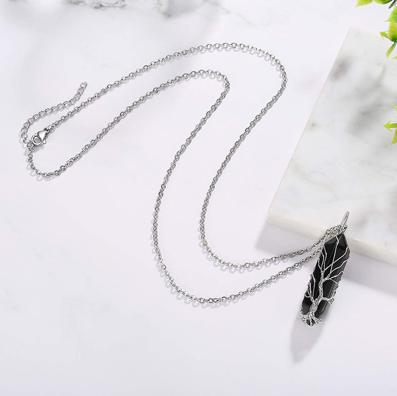 Silberne Halskette mit schwarzem Federanhänger auf Marmorhintergrund, Modeschmuck Accessoire.