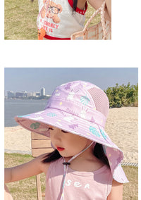 Mädchen mit lila Sonnenhut mit Hasenmotiv am Strand, Sommermode, Kinderbekleidung.