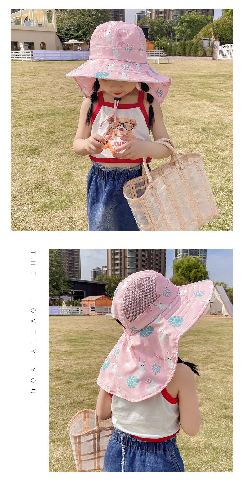 Mädchen mit rosa Sonnenhut und Strohtasche im Park.