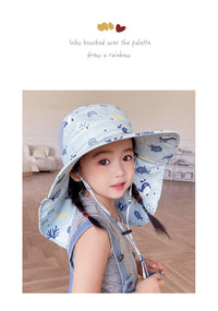 Mädchen mit blauem Sonnenhut, Regenbogenmuster, Innenraum, Kinderbekleidung, Sommeraccessoire.