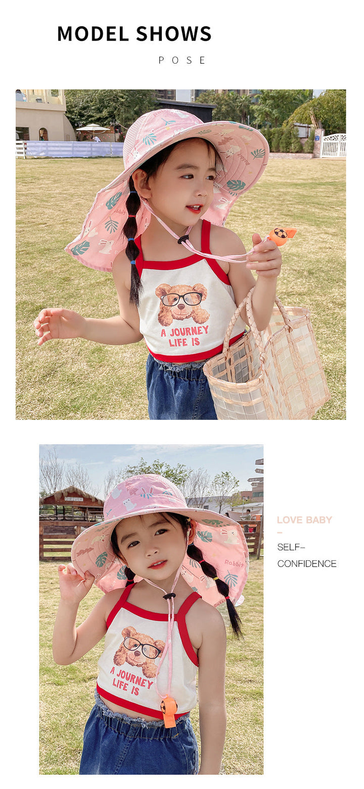 Mädchen mit rosa Sonnenhut und Sommeroutfit, lächelnd im Freien.