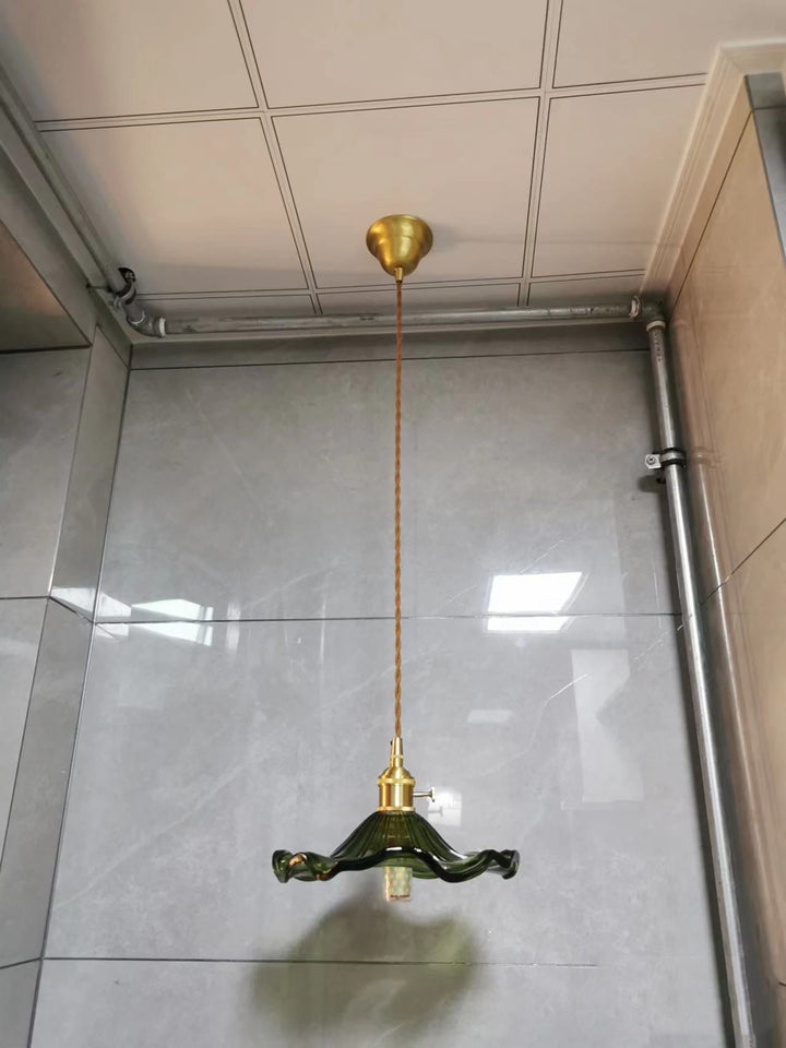 Grüne Vintage-Hängelampe aus Glas mit Messingfassung in modernem Badezimmer.