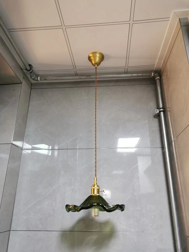 Grüne Vintage-Hängelampe aus Glas mit Messingfassung in modernem Badezimmer.