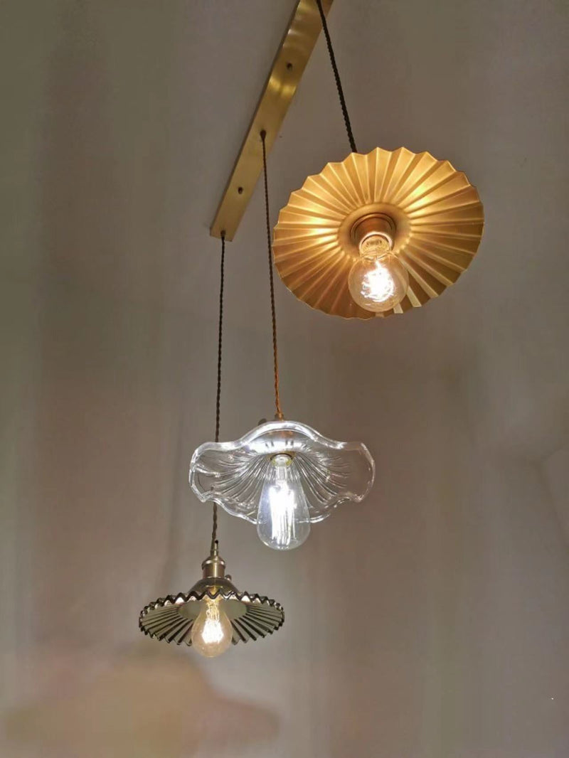 Drei Vintage-Hängelampen aus Glas und Metall in verschiedenen Designs und Farben.