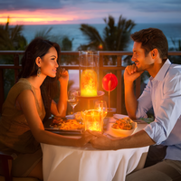 Paar beim romantischen Abendessen am Strand, Kerzenlicht, Sonnenuntergang, tropische Kulisse.