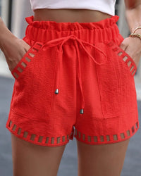 Damen rote Sommer-Shorts mit Kordelzug, Taschen und Häkel-Details, lässige Strandmode.