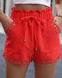 Damen rote Sommer-Shorts mit Kordelzug, Taschen und Häkel-Details, lässige Strandmode.