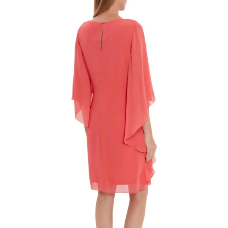 Frau in korallenrotem Chiffonkleid mit Flügelärmeln, elegantes Sommeroutfit.