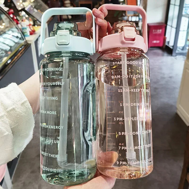 Zwei transparente Wasserflaschen mit Zeitmarkierungen, rosa und blau, Kunststoff, 2 Liter.