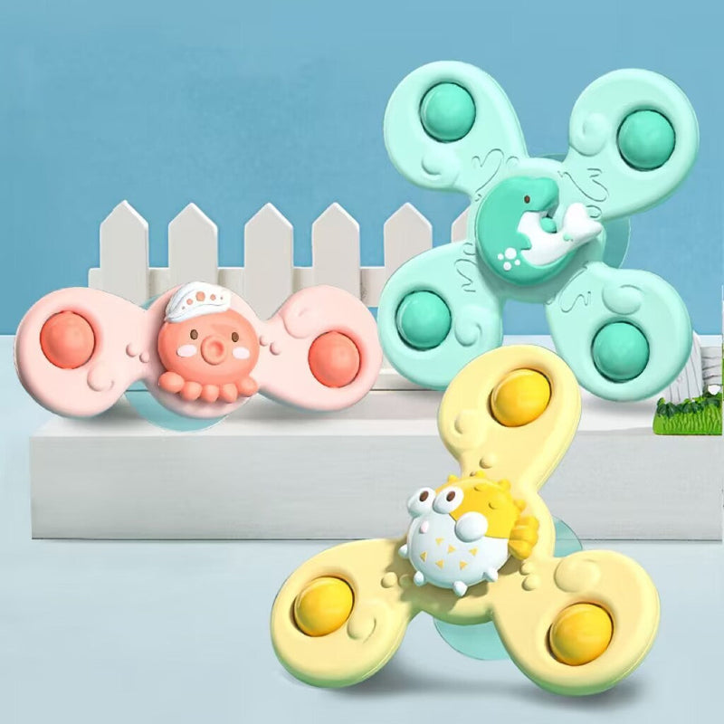 Drei bunte Baby-Fidget-Spinner mit Tiermotiven vor blauem Hintergrund.