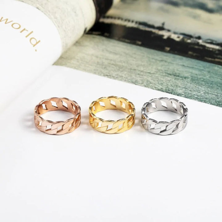 Drei geflochtene Ringe in Roségold, Gold und Silber auf weißem Hintergrund, Schmuckdesign.