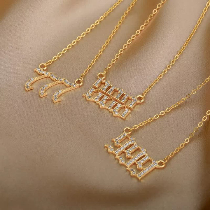 Drei goldene Namensketten mit Diamanten auf beigem Hintergrund, personalisierter Schmuck.