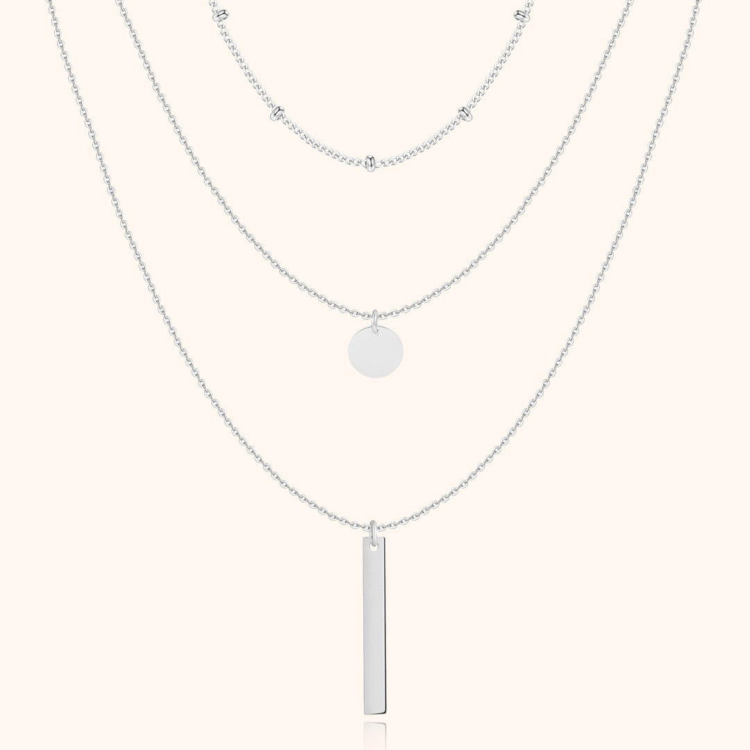Silberne Halskette mit drei Lagen, Anhänger und Kugeldetails, eleganter Schmuck für Damen.