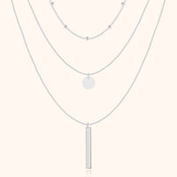Silberne Halskette mit drei Lagen, Anhänger und Kugeldetails, eleganter Schmuck für Damen.