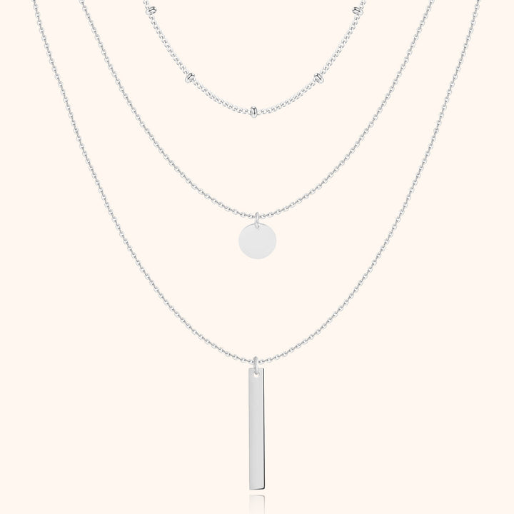 Silberne Halskette mit drei Lagen, Anhänger und Kugeldetails, eleganter Schmuck für Damen.