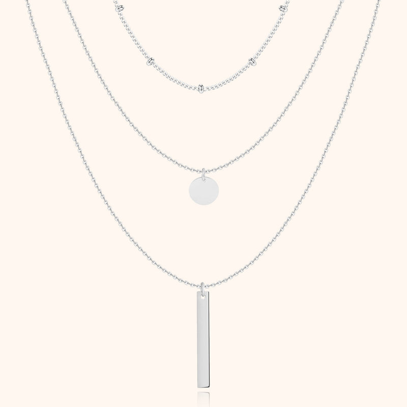 Silberne Halskette mit drei Lagen, Anhänger und Kugeldetails, eleganter Schmuck für Damen.
