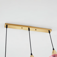 Goldene Deckenleuchte mit drei schwarzen Kabeln, modernes Design, minimalistische Beleuchtung.