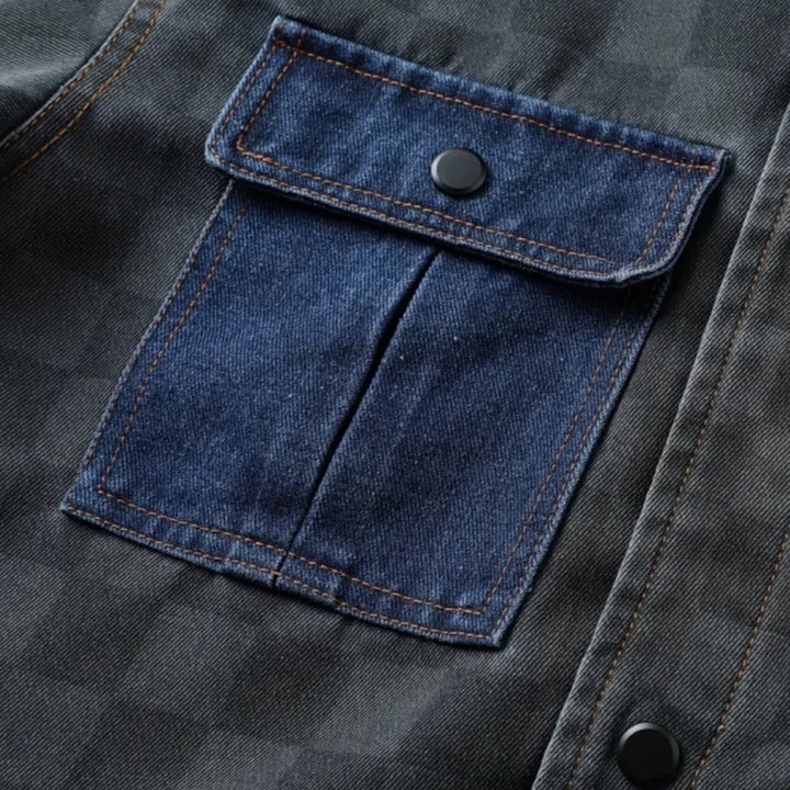 Dunkelblaue Jeansjacke mit Knopftasche, kariertes Muster, robuste Baumwolle, modisch.