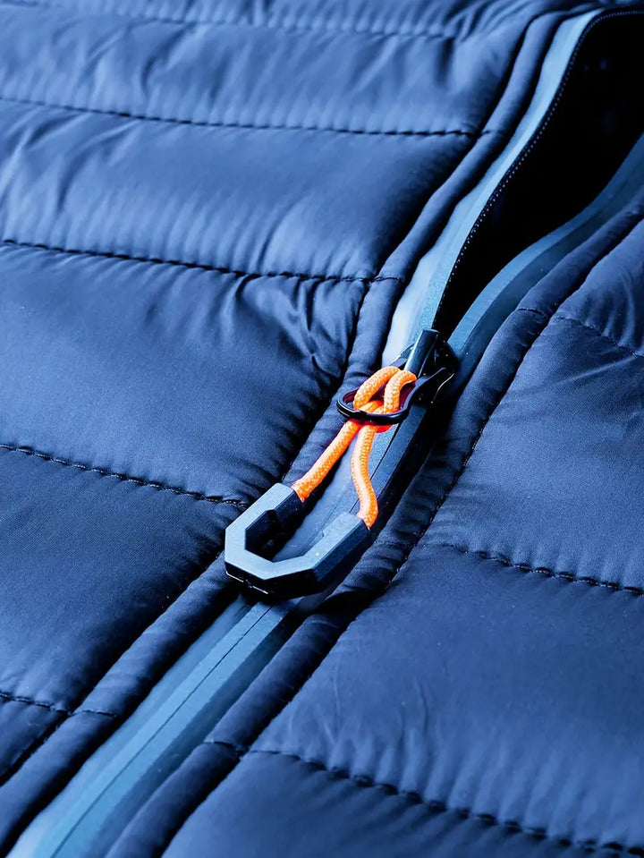 Dunkelblaue Steppjacke mit Reißverschluss, orange Kordel, Wintermode, isoliert, wasserabweisend.
