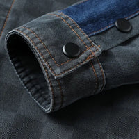 Grauer Jeansstoff-Ärmel mit blauen Akzenten und schwarzen Knöpfen, Nahaufnahme.