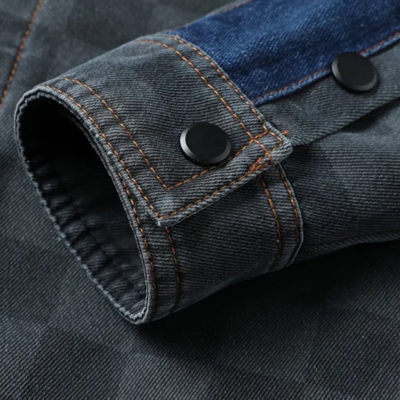 Grauer Jeansstoff-Ärmel mit blauen Akzenten und schwarzen Knöpfen, Nahaufnahme.