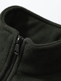 Dunkelgrüner Fleece-Pullover mit Reißverschluss, weiches Material, Outdoor-Bekleidung.