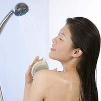 Frau duscht mit Duschkopf und Körperbürste, Wellness, Entspannung, Hautpflege.