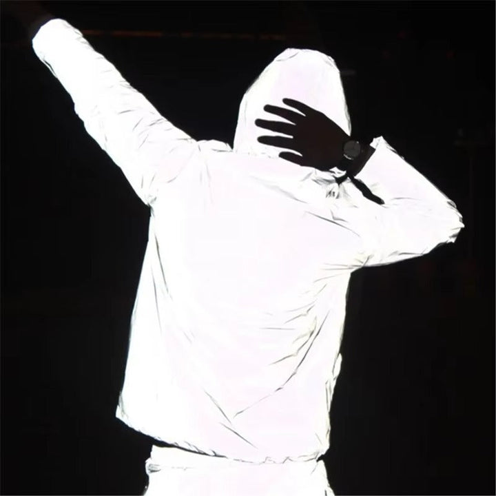 Reflektierende weiße Jacke mit Kapuze, Person von hinten, Nacht, modisch, Outdoor-Bekleidung.