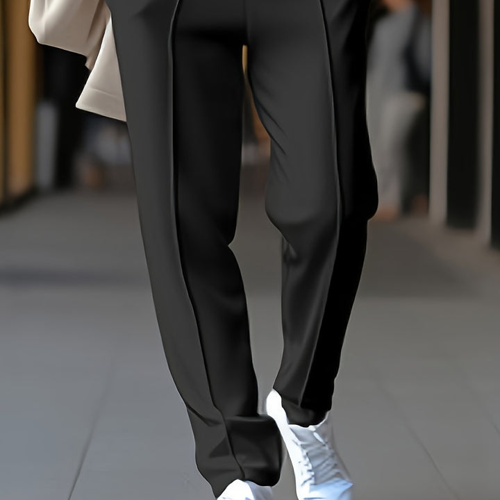 Schwarze Damenhose, elegant, aus Baumwolle, mit weißen Sneakern, modisch, bequem.