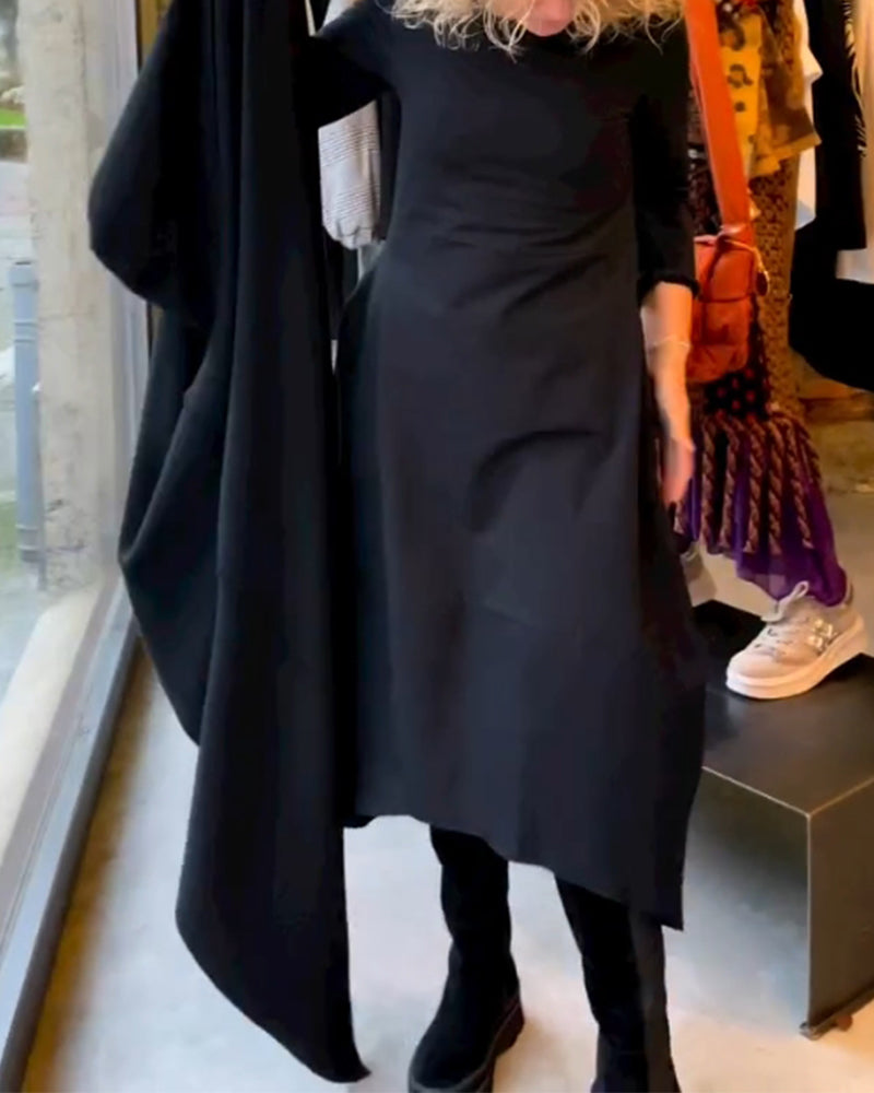 Frau in schwarzem Kleid mit langen Ärmeln, hält Stoff, Modegeschäft, Schaufenster, Herbstmode.