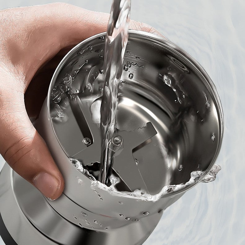 Hand hält Edelstahl-Mixer, Wasser wird eingefüllt, Küchenzubehör, langlebig, modern.