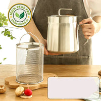 Person hält Edelstahl-Ölkanne, PFAS-frei, mit Siebkorb auf Holztisch, umweltfreundlich.