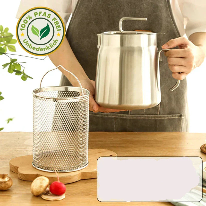 Person hält Edelstahl-Ölkanne, PFAS-frei, mit Siebkorb auf Holztisch, umweltfreundlich.