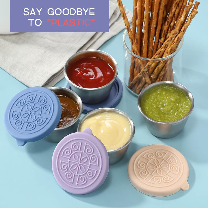 Wiederverwendbare Silikondeckel auf Edelstahlbehältern mit Saucen, umweltfreundlich, bunt.