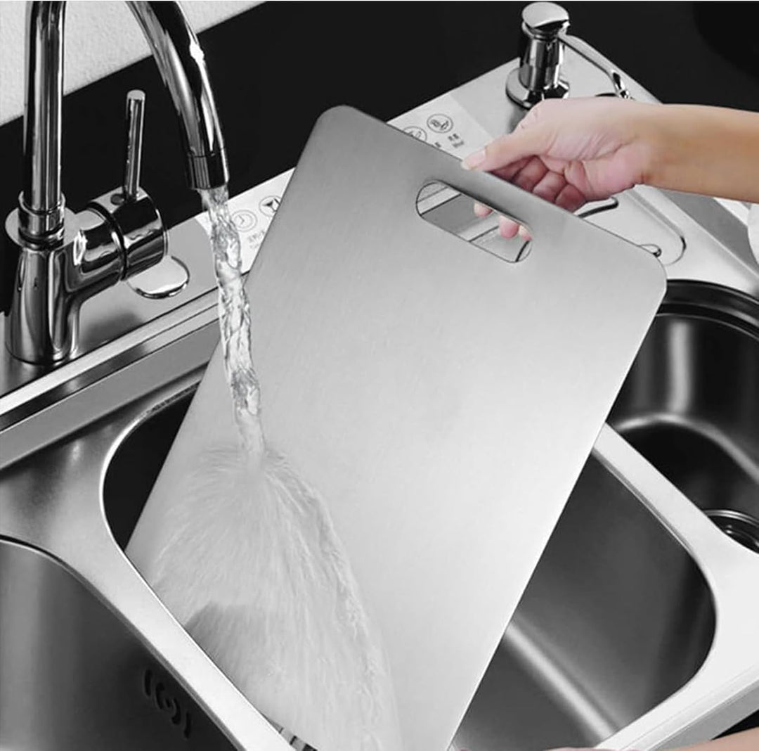 Hand wäscht Edelstahl-Schneidebrett im Spülbecken, modernes Küchendesign, langlebig.