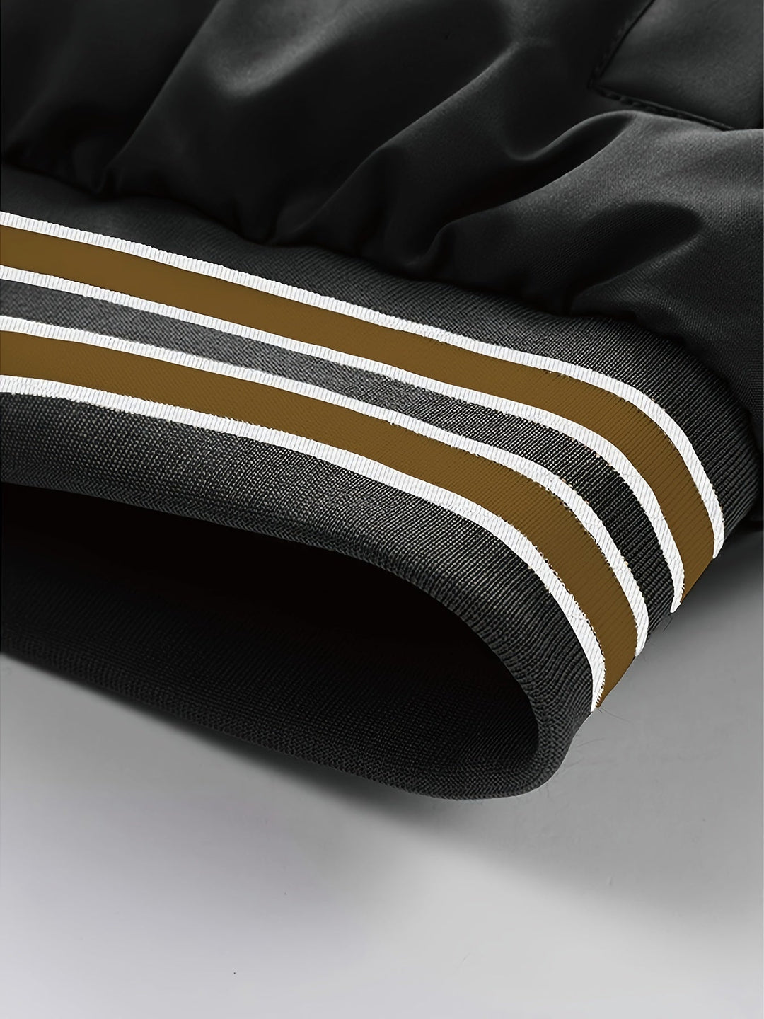 Schwarze Jacke mit braunen und weißen Streifen, modisch, Detailansicht, Polyester.