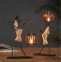 Zwei schwarze Metallfiguren mit Laternen, dekorative Tischlampen, rustikales Design.